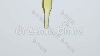 特写草油滴落在吸管上，白色背景和吸管垂直保持。